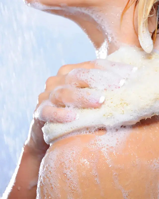 Person applying soap to their shoulder with a blurred background