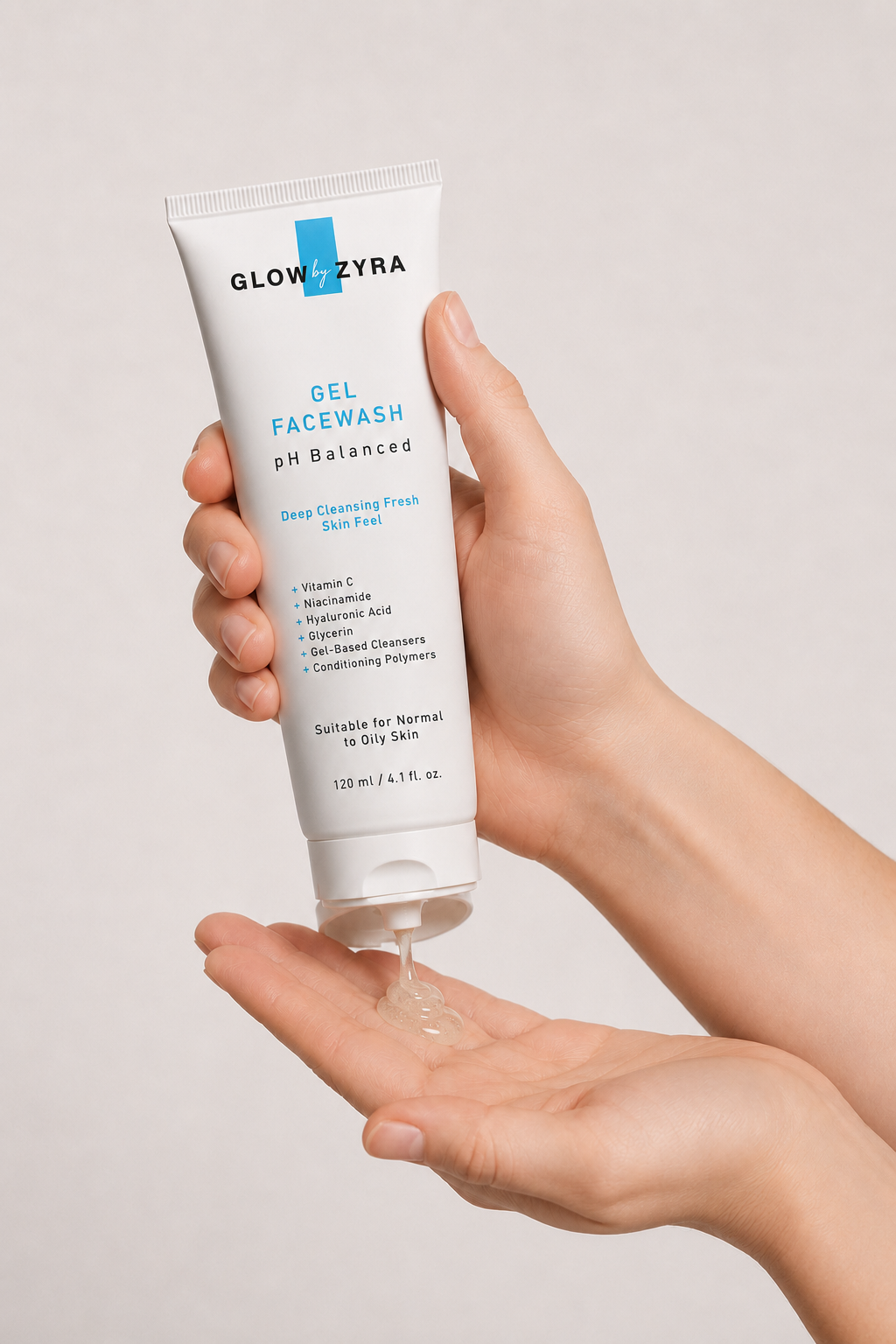 Hand holding a tube of Glow by zyra Gel Facewash with visible product on palm against a neutral background