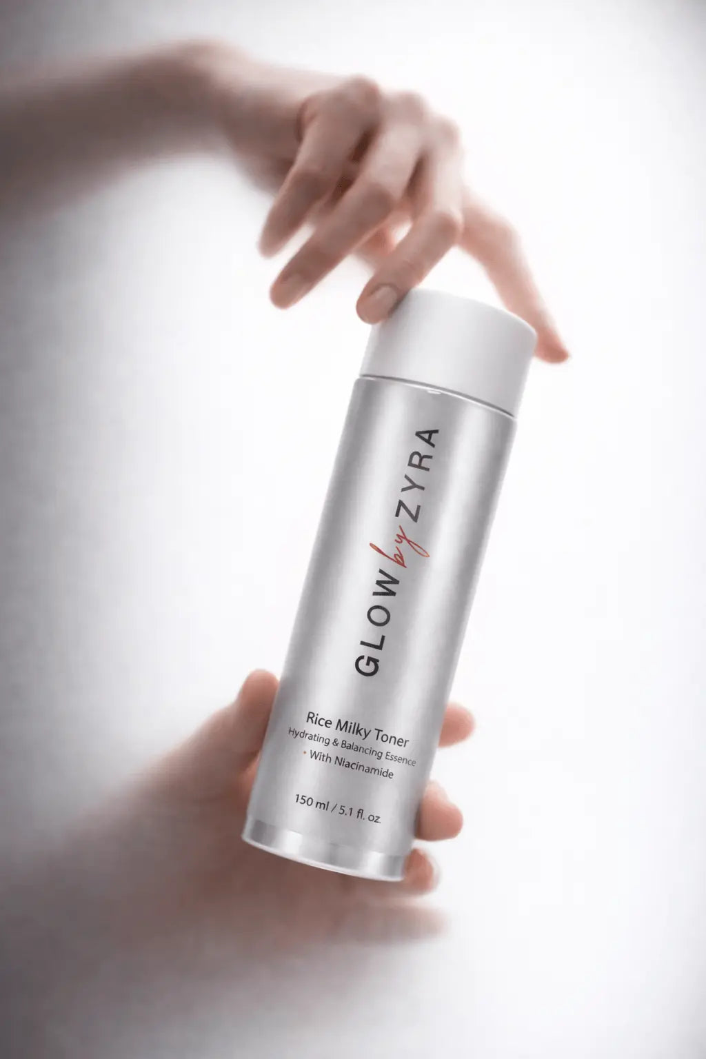 Glow Zyra toner bottle held by a hand on a light background
