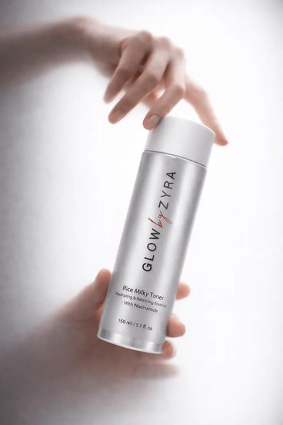 Glow Zyra toner bottle held by a hand on a light background