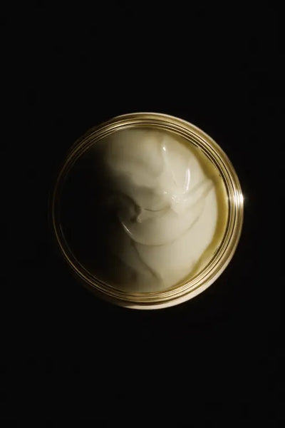 Jar of white cream on a black background
