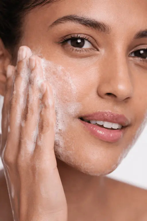 Woman applying a facial cleanser to her face